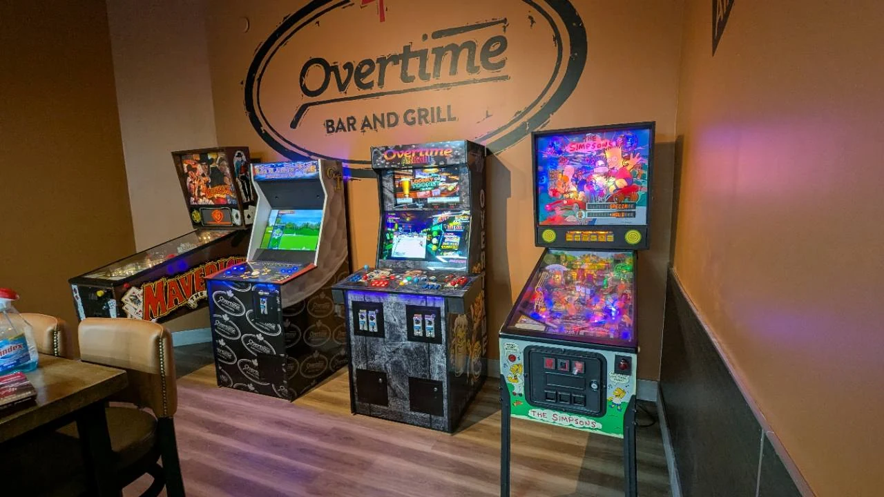 Maverick pinball, Golden Tee, a custom 705Arcade commercial machine, and The Simpsons pinball at Overtime Kingsway