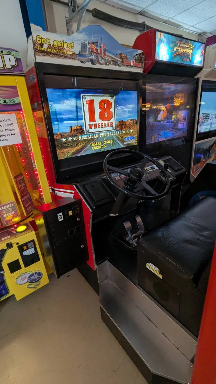 Steering wheel, pedals, and bench seat on the Sega 18 Wheeler arcade machine