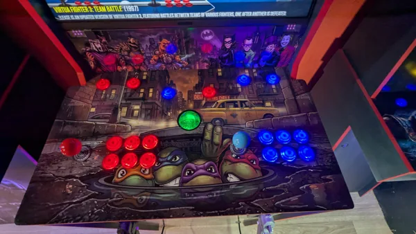 TMNT two-player control deck with red and blue buttons and integrated trackball
