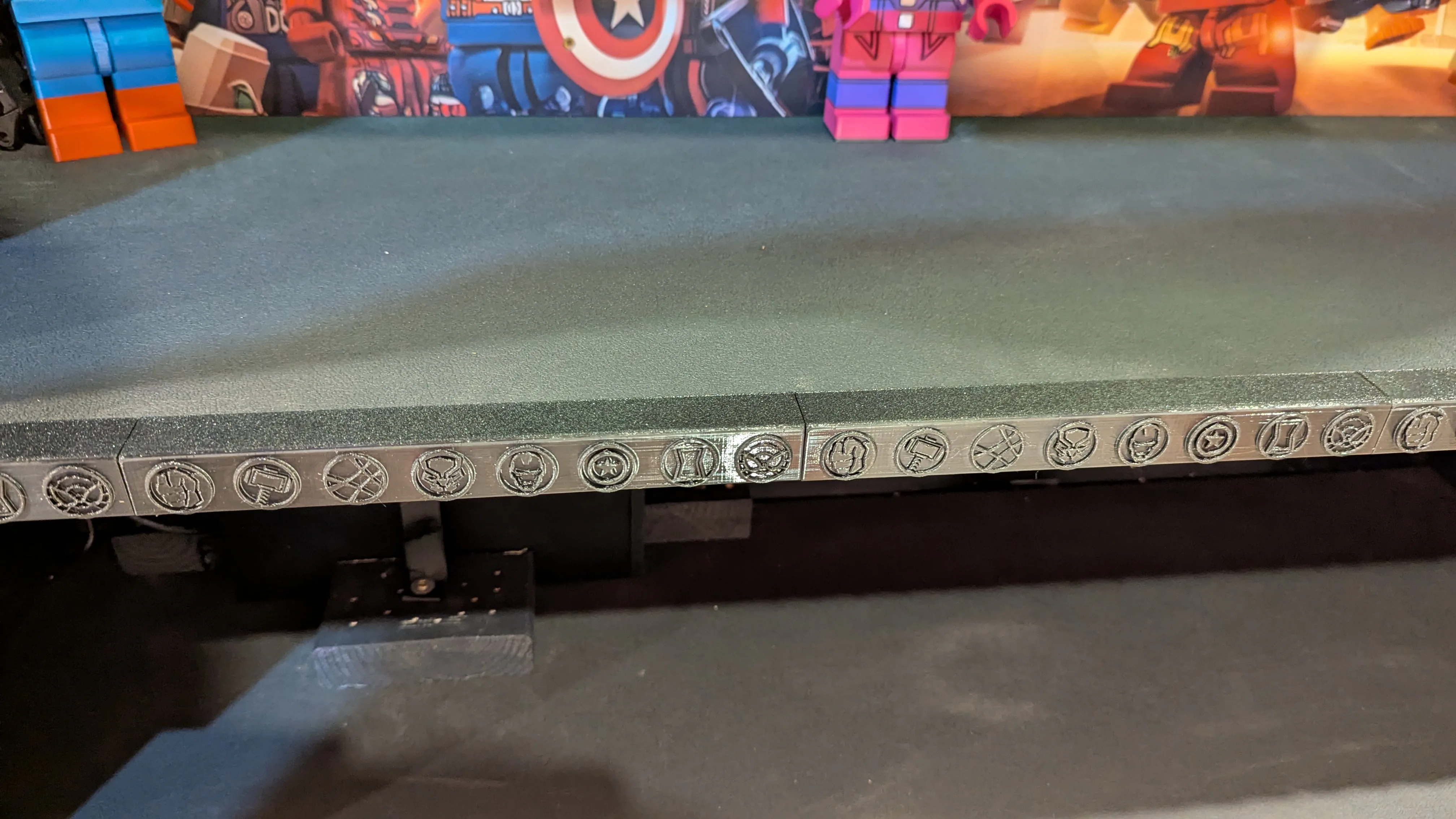 Close detail of Avengers icon trim on custom LEGO Marvel pedestal shelf