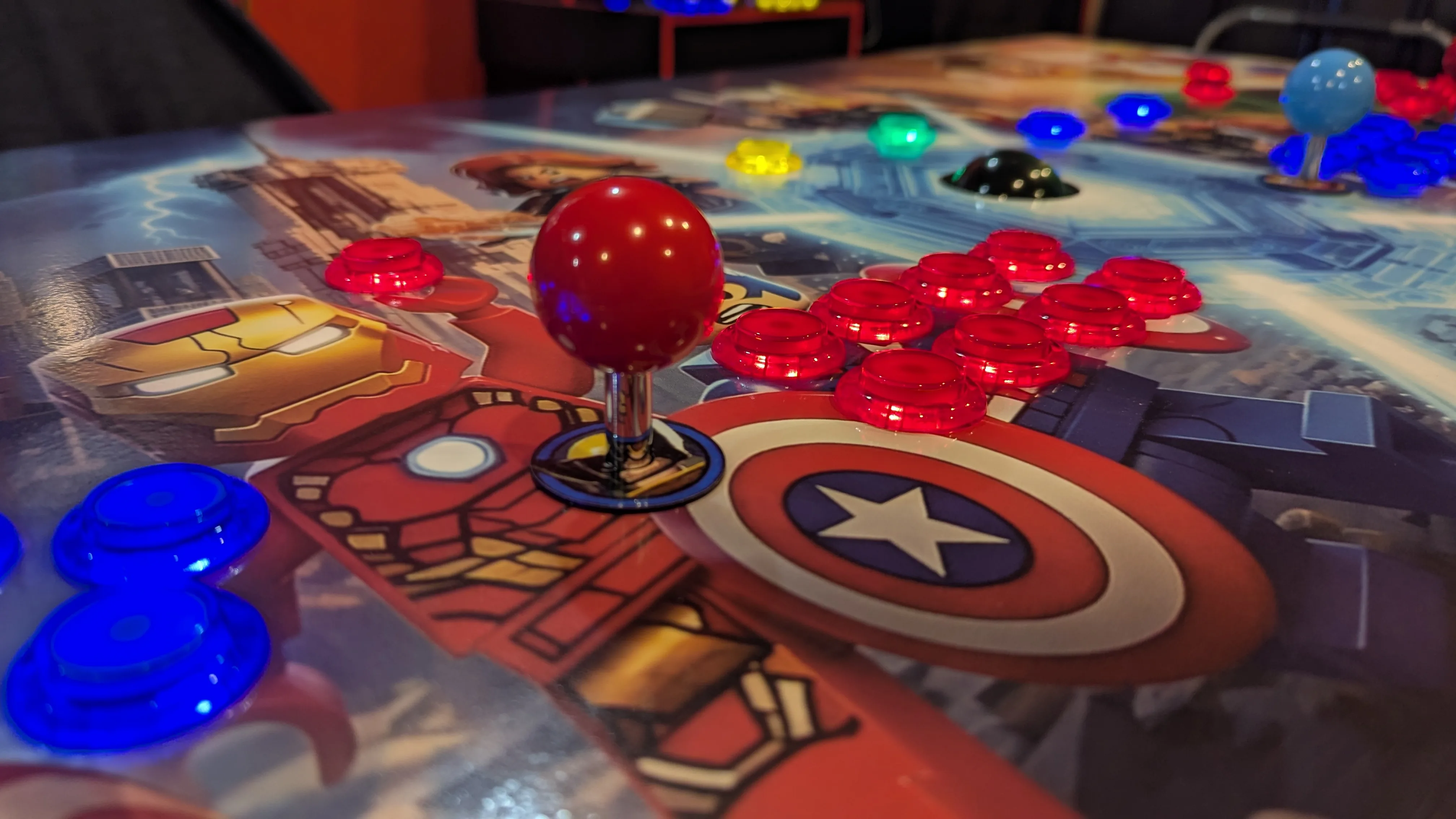Close-up of red joystick and LED buttons on Captain America control area