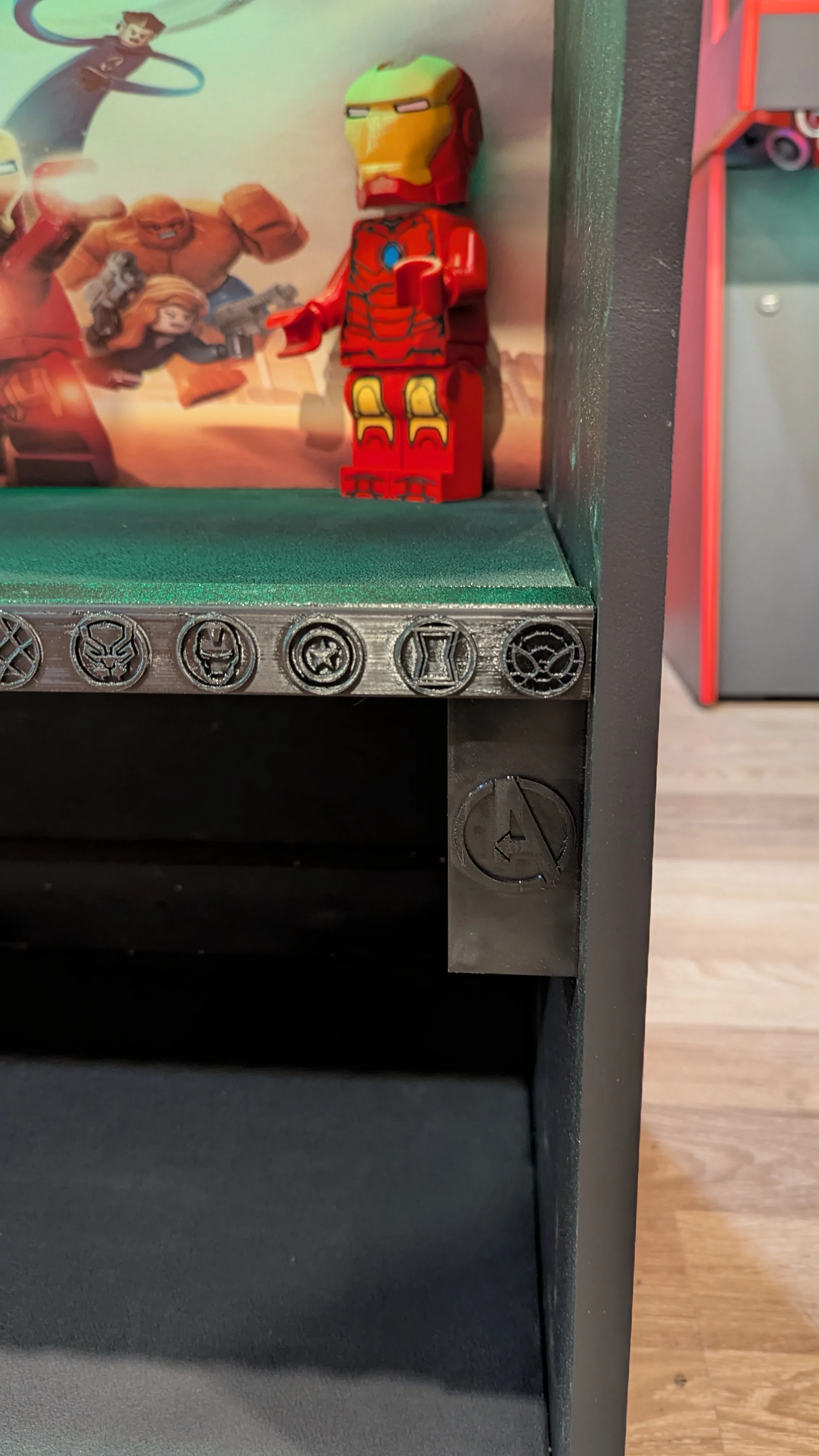 Close detail of Iron Man figure and Avengers icon trim on the display shelf