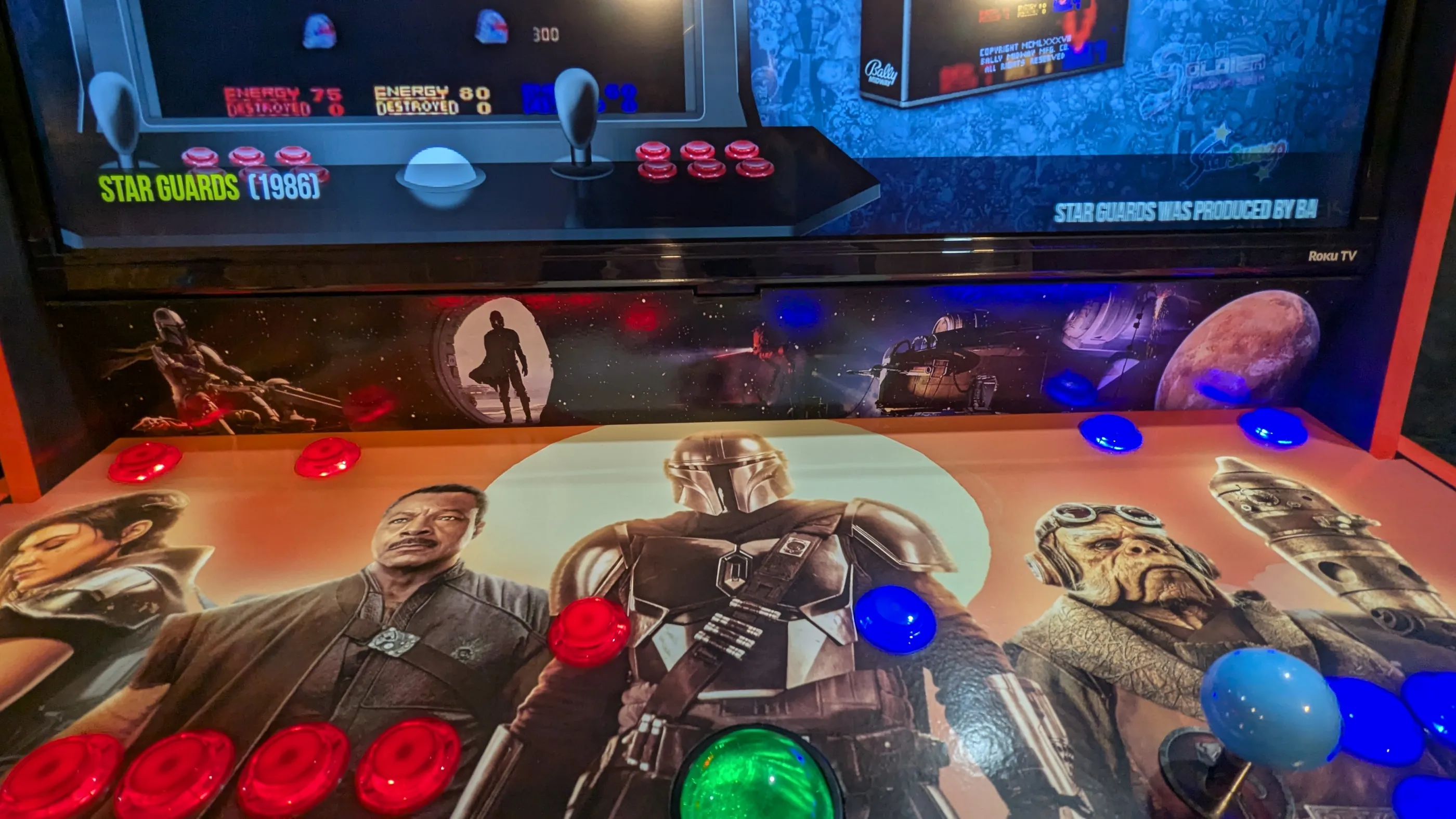 Mandalorian arcade control panel with red and blue LED controls, trackball, and 32-inch display
