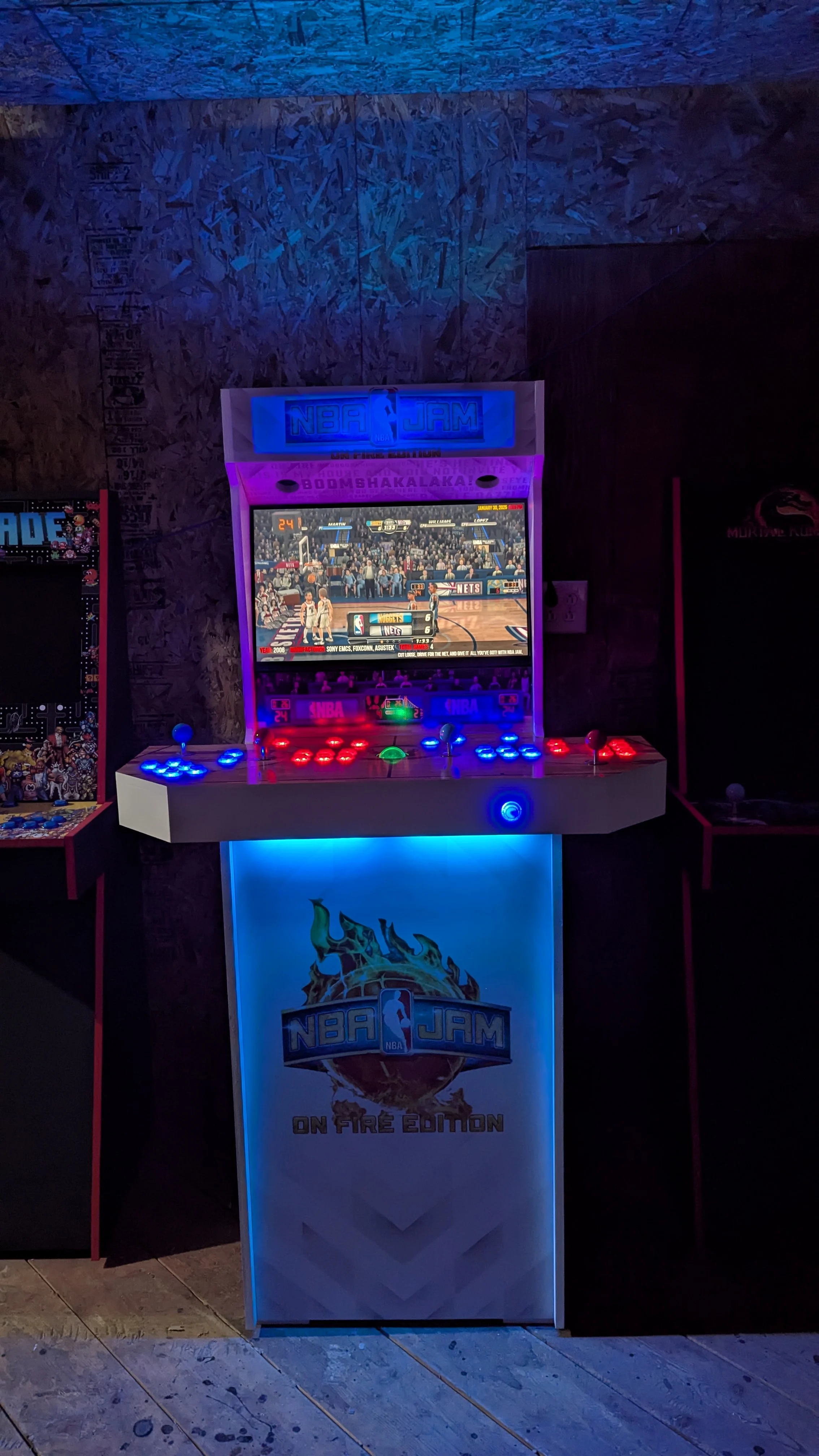 Full NBA Jam arcade machine glowing blue and purple in a dark room
