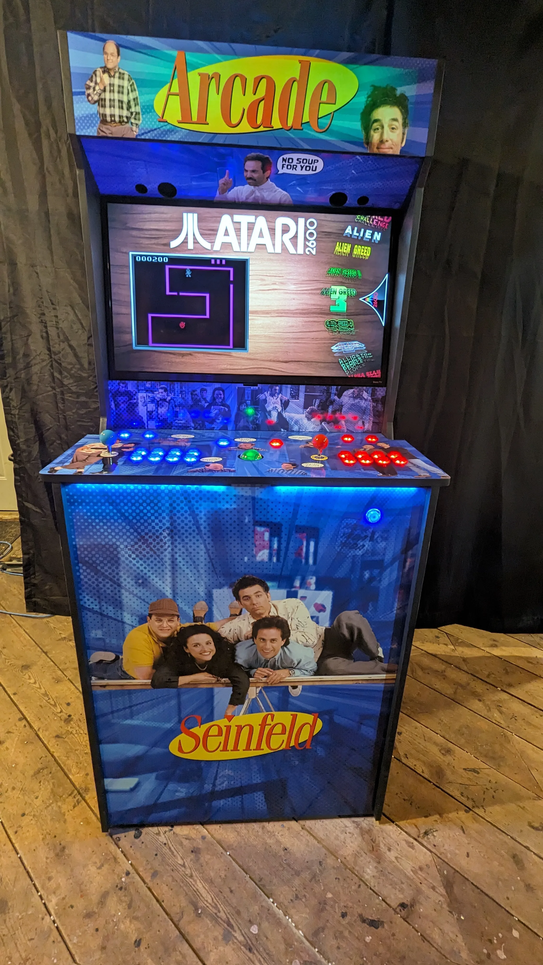 Front view of the Seinfeld Epic arcade machine with illuminated controls